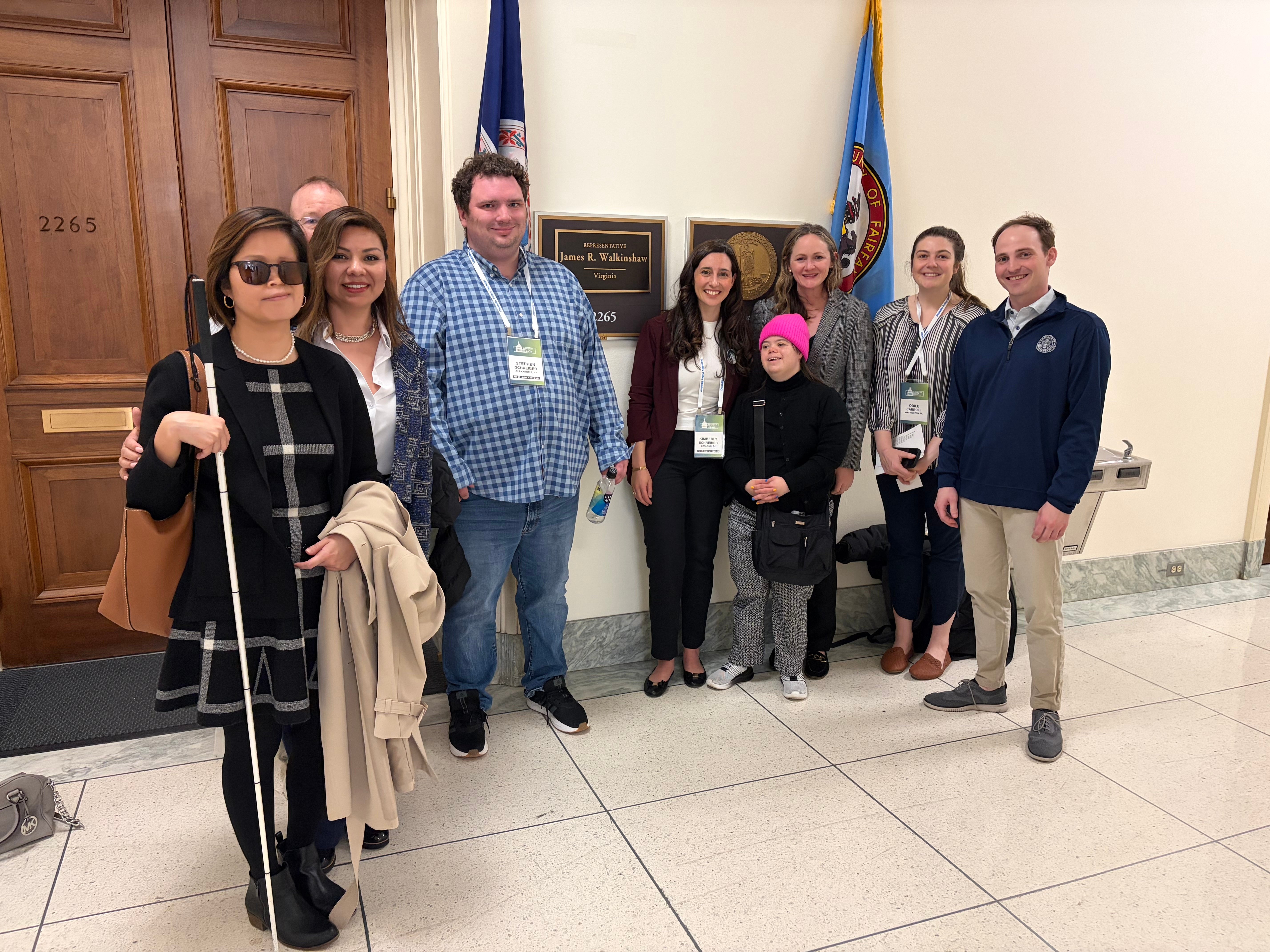 A group of people including Kim and Stephen poses in a congressional hallway outside the office of Representative James R. Walkinshaw of Virginia.