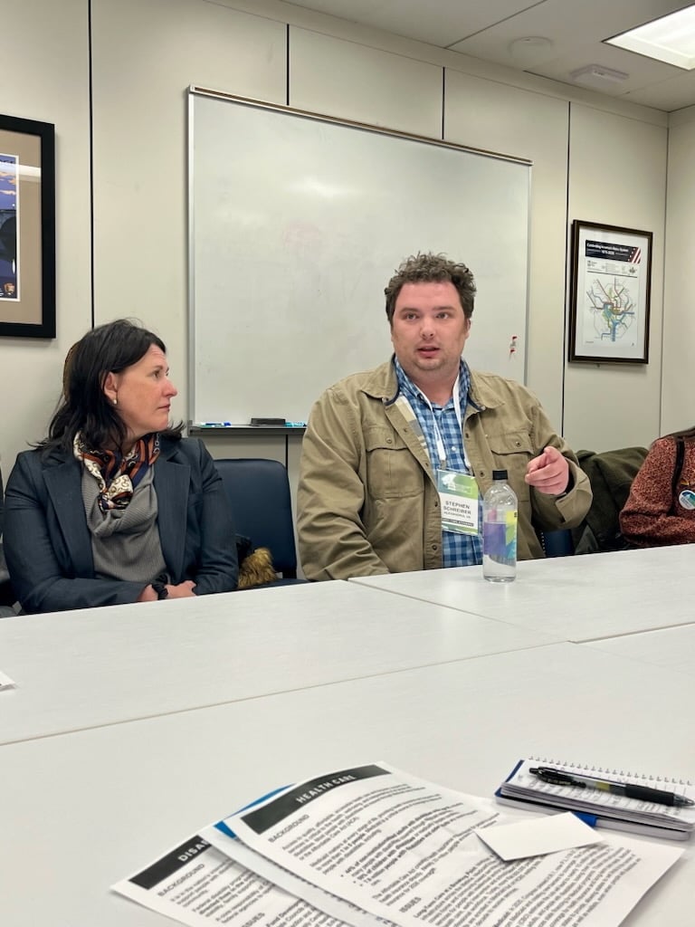 Stephen Schreiber speaks at a conference room table during a meeting with congressional staffers.