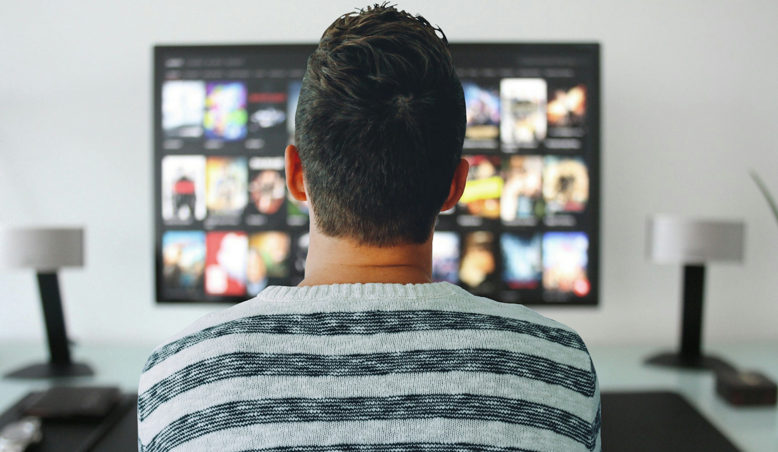 Person facing a TV with a menu of movies and shows