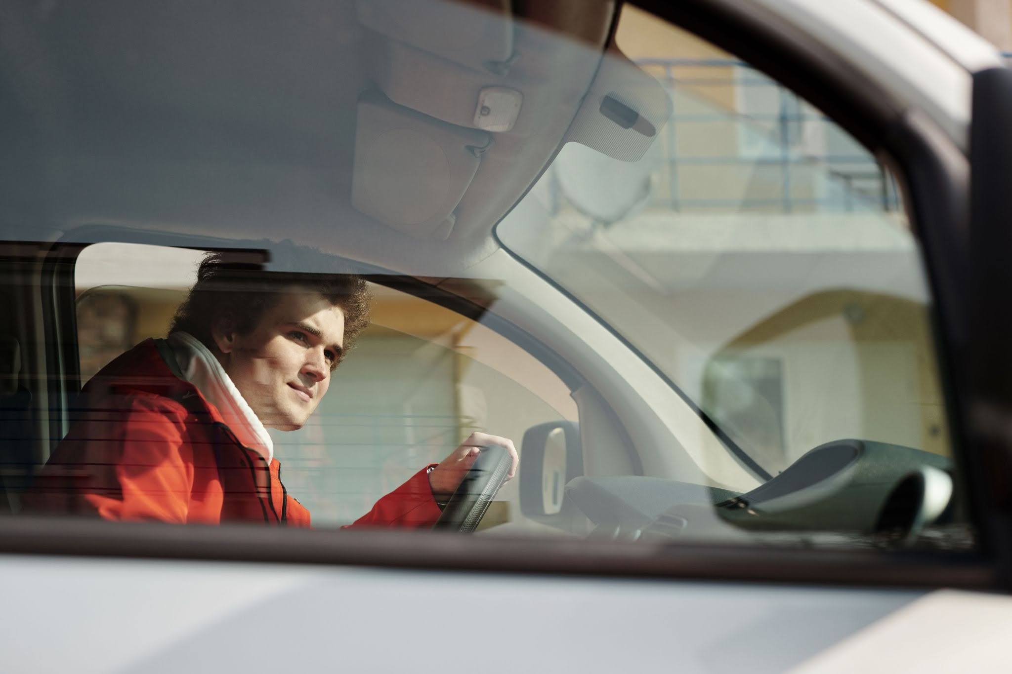 An adult with autism drives by an office complex and checks the view on his right side