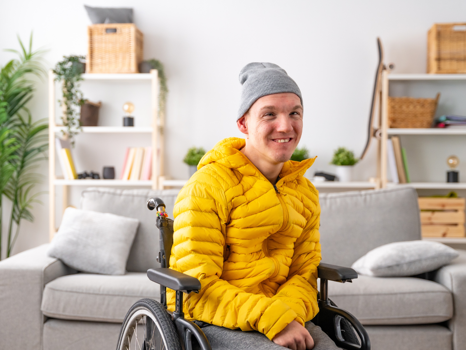 An adult with a disability in a wheelchair smiling