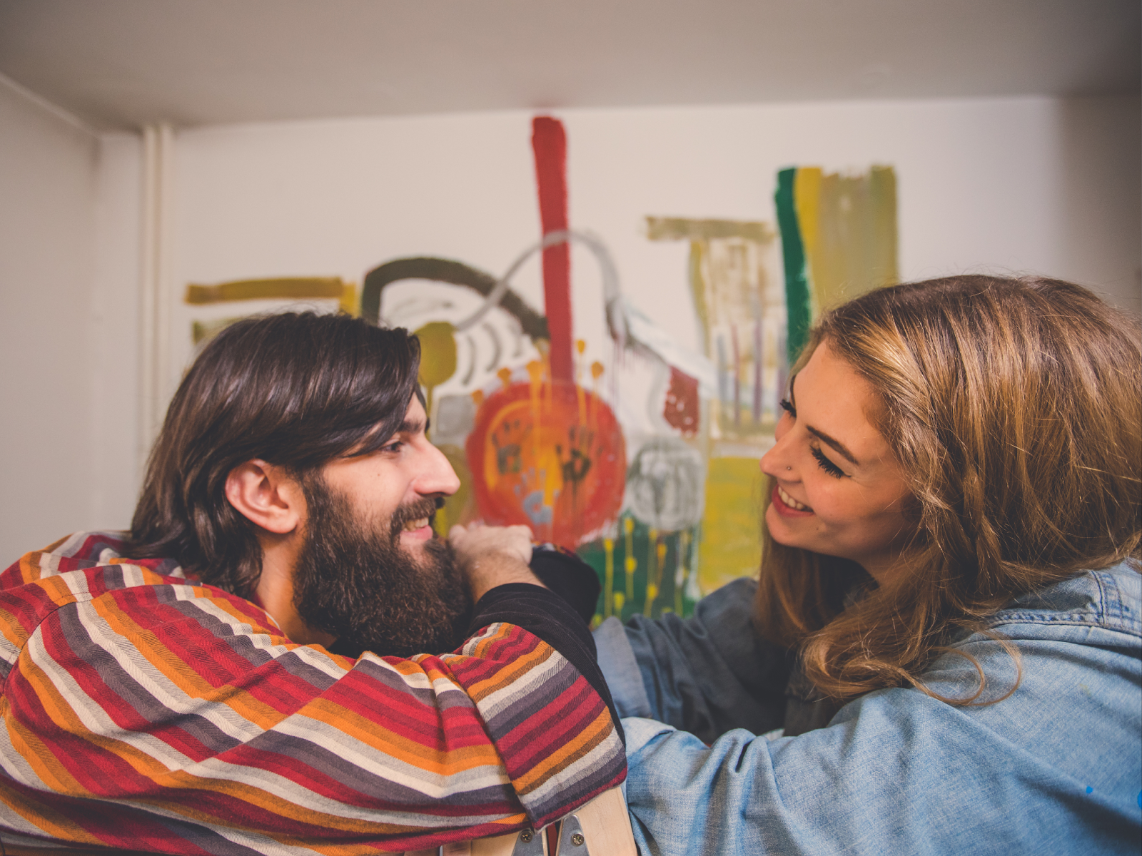 Two adults making direct eye contact, both smiling and engaging in conversation.