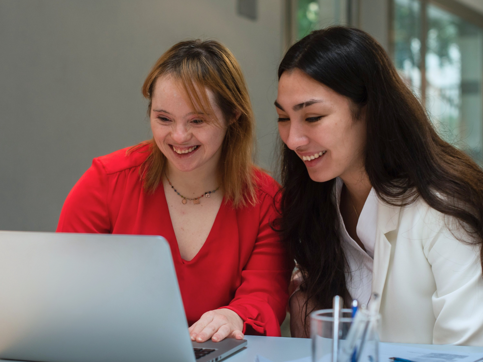 A woman and a member of her circle of support sit together and discuss her person-centered planning ideas