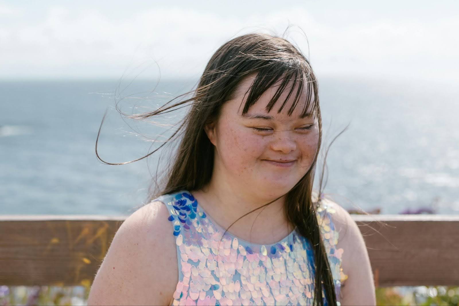 Headshot of a young woman smiling with water in the background