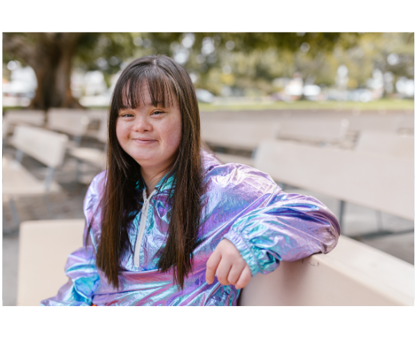 A woman with down syndrome sitting on a bench