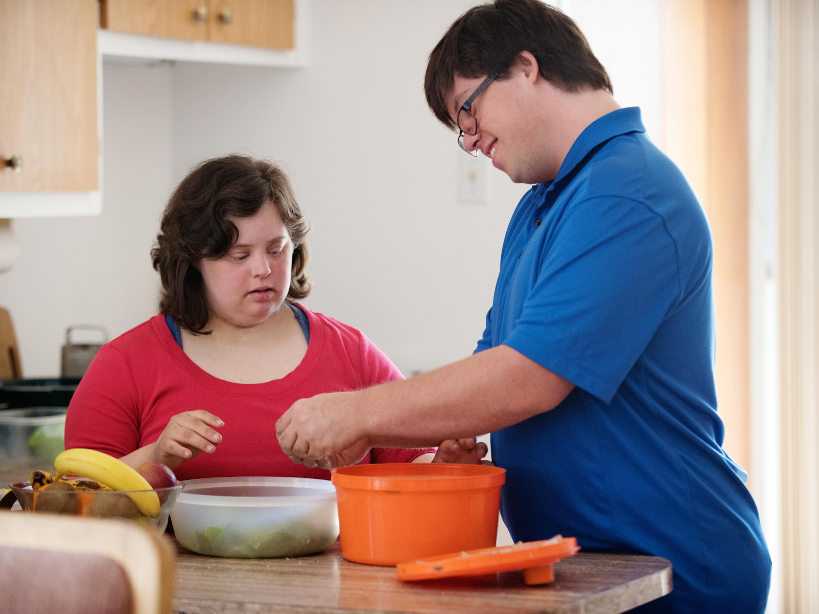 Two adults with disabilities in a kitchen preparing food together