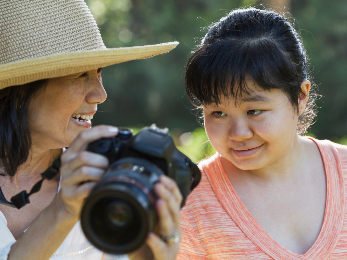 A woman shows a photo to another woman on a camera. Featured image for Top 9 Gifts for Autistic Adults