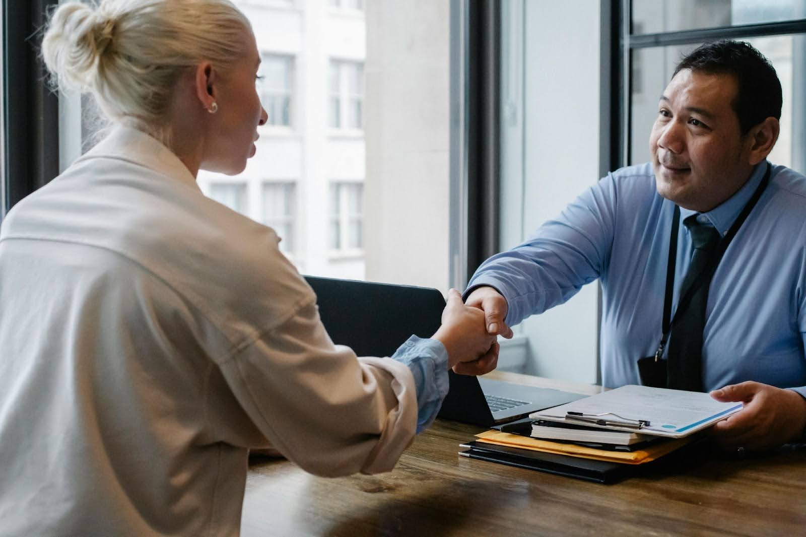 Two people shaking hands over a table