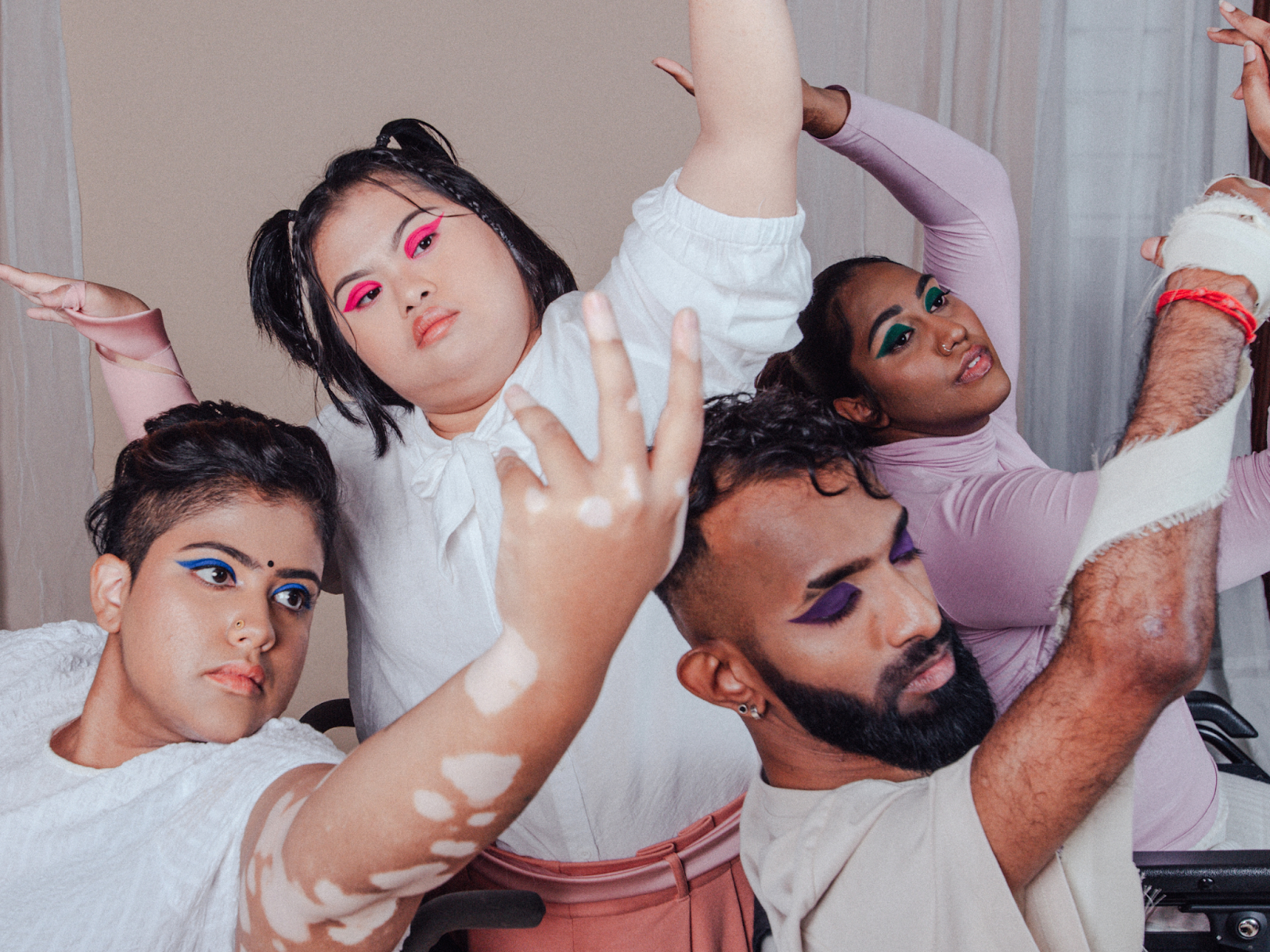 A diverse group of people with colorful eye makeup posing artistically