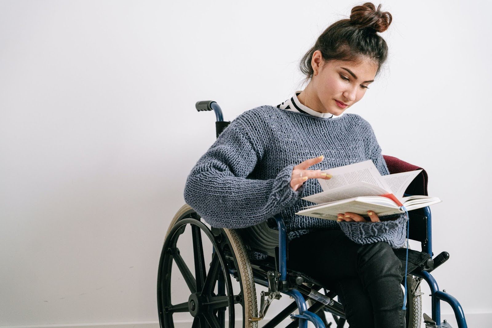 A woman in a wheelchair reads a book