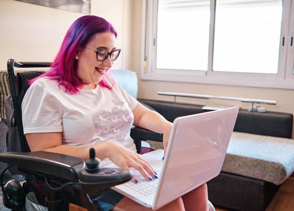 A woman in a wheelchair uses a laptop