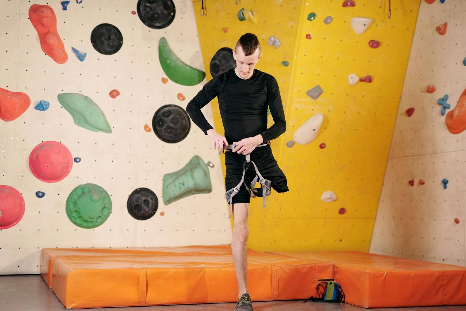 A man with one leg puts on a belt so he can rock climb