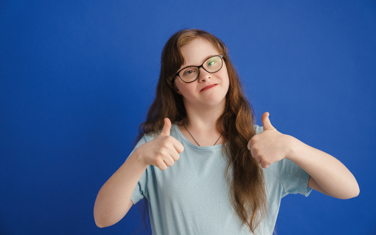 A disabled woman gives two thumbs up
