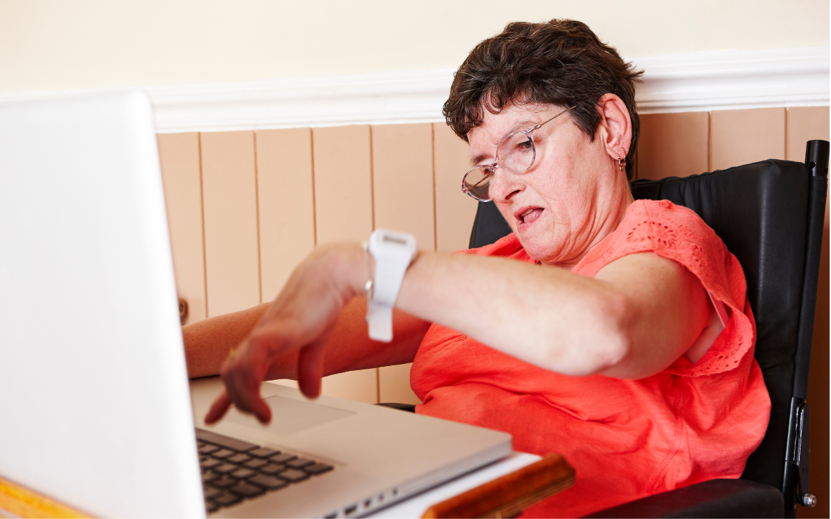 A woman with a disability types on a computer