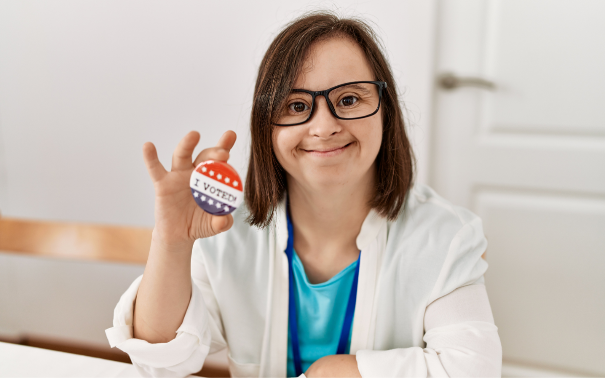 A voter with disabilities holding an I Voted pin