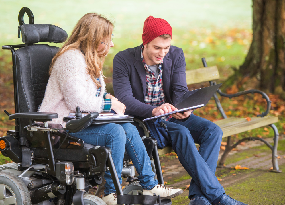 Two people sit in a park
